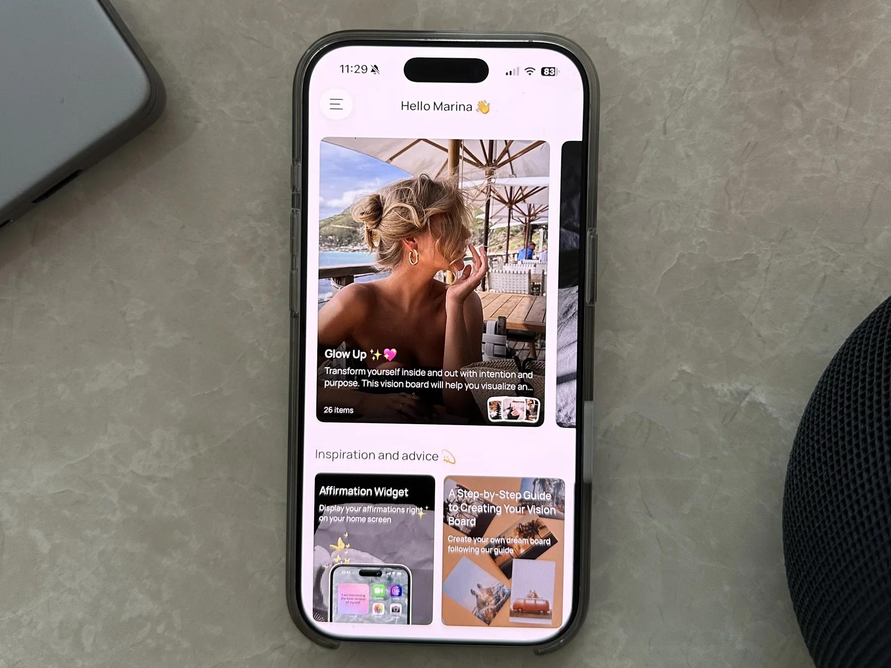 Ein iPhone auf einem Marmortisch zeigt die VISIYA App mit dem Glow-Up-Board und Affirmationen