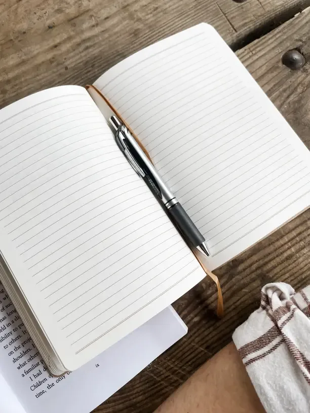 Ein aufgeschlagenes Notizbuch mit Stift, bereit für deine Zielliste