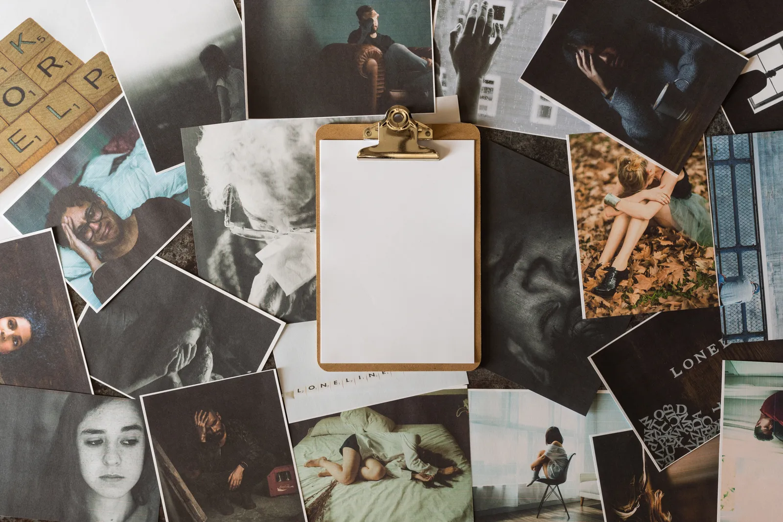 A flat-lay of printed photos and Polaroids arranged around a blank clipboard, ready for a vision board