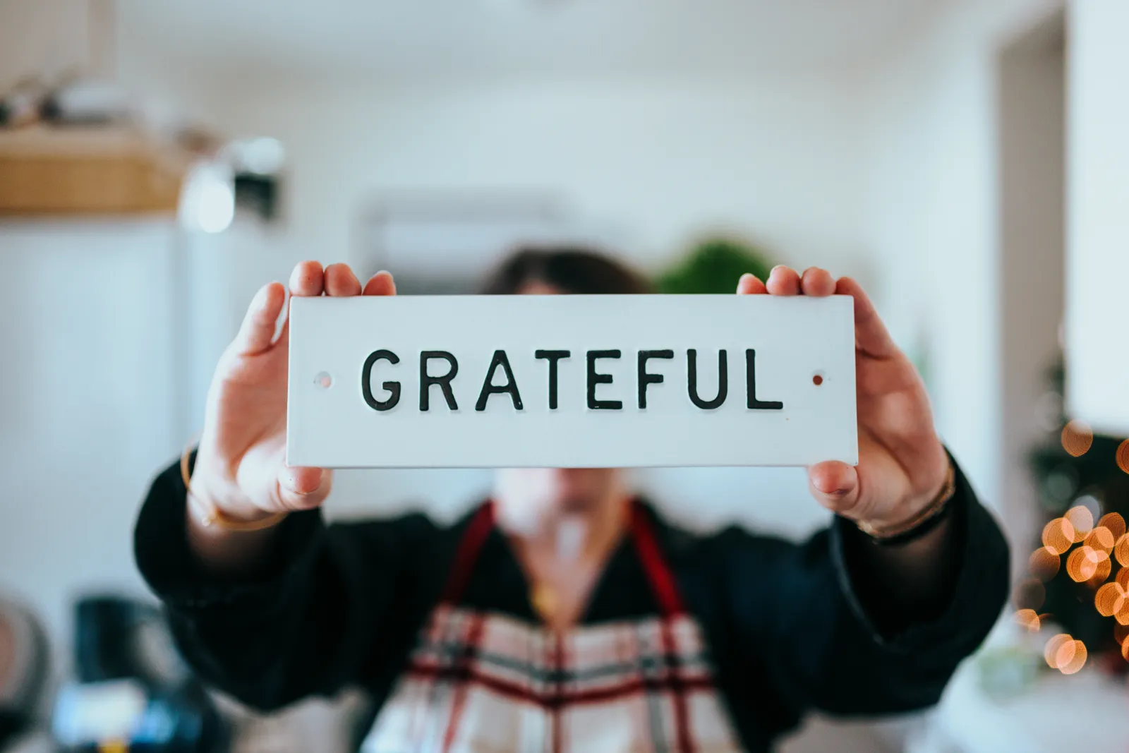 Hands holding a card that reads "Grateful"