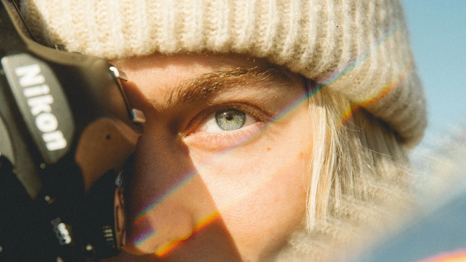 A close-up of a focused eye beside a camera lens, symbolising clear intentions
