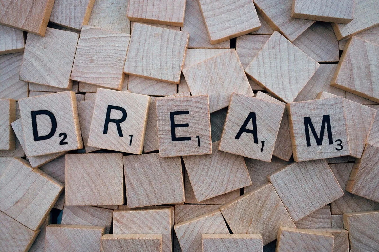 Дерев'яні плитки зі скрабл-літерами, що складаються у слово «DREAM» (мрія)