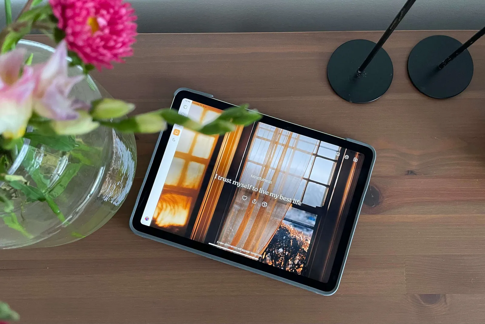 Ein iPad auf einem Holztisch zeigt die VISIYA Affirmation „I trust myself to live my best life", daneben eine Glasvase mit rosa Blumen