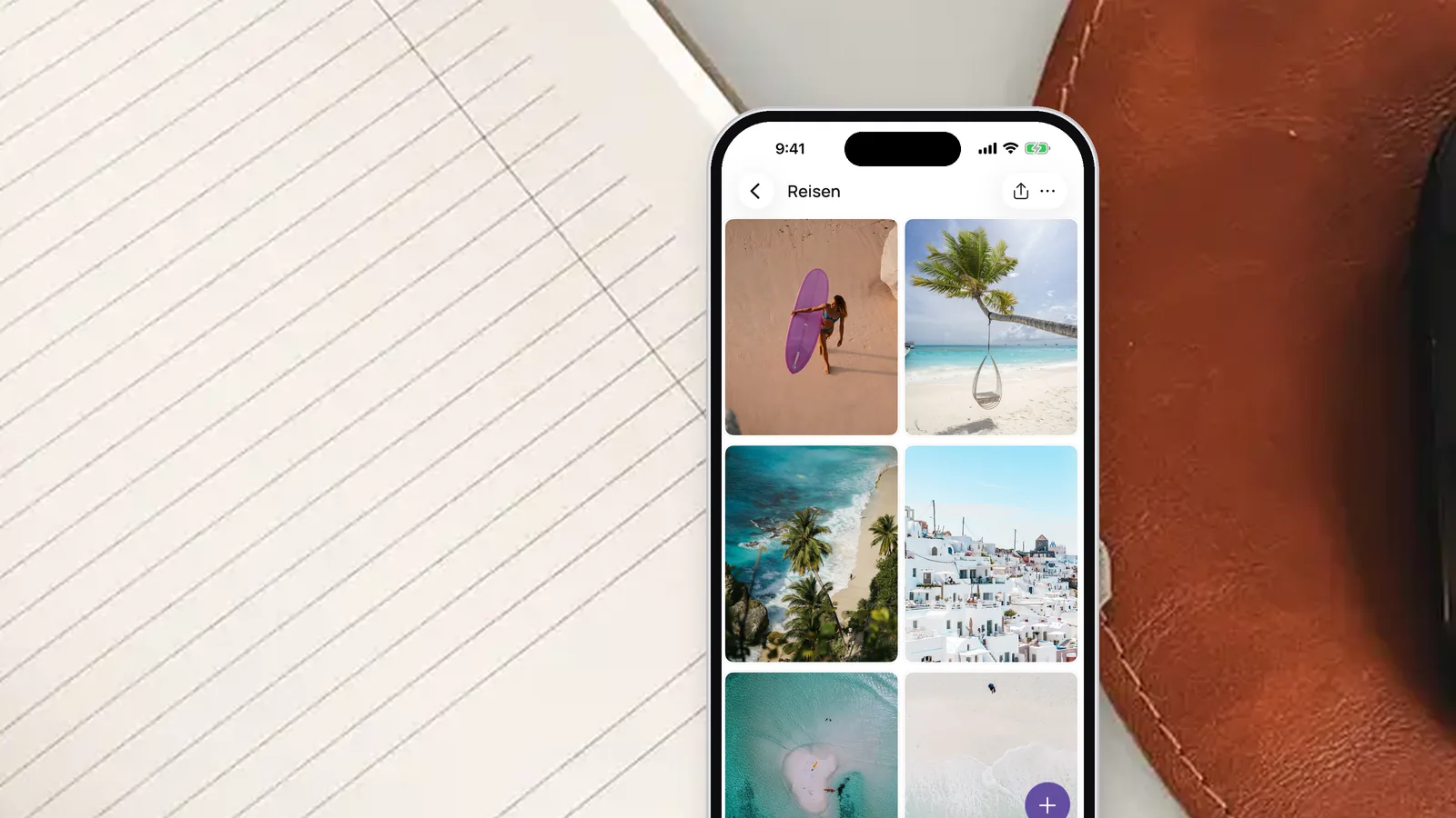 Ein iPhone auf einem aufgeschlagenen Notizbuch, in der VISIYA App der Bereich Reisen eines Vision Boards mit Strand- und Inselfotos