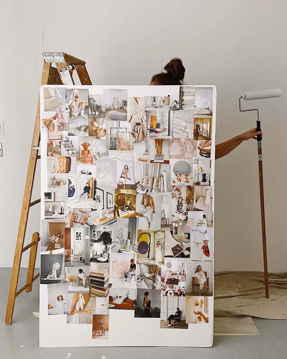 A dreamy neutral-toned vision board poster held up in a studio