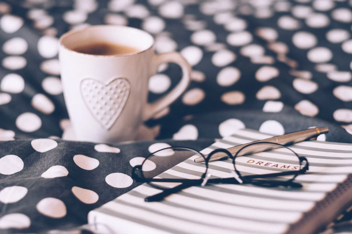 A calm morning scene with a hot coffee and an open dream journal on a desk
