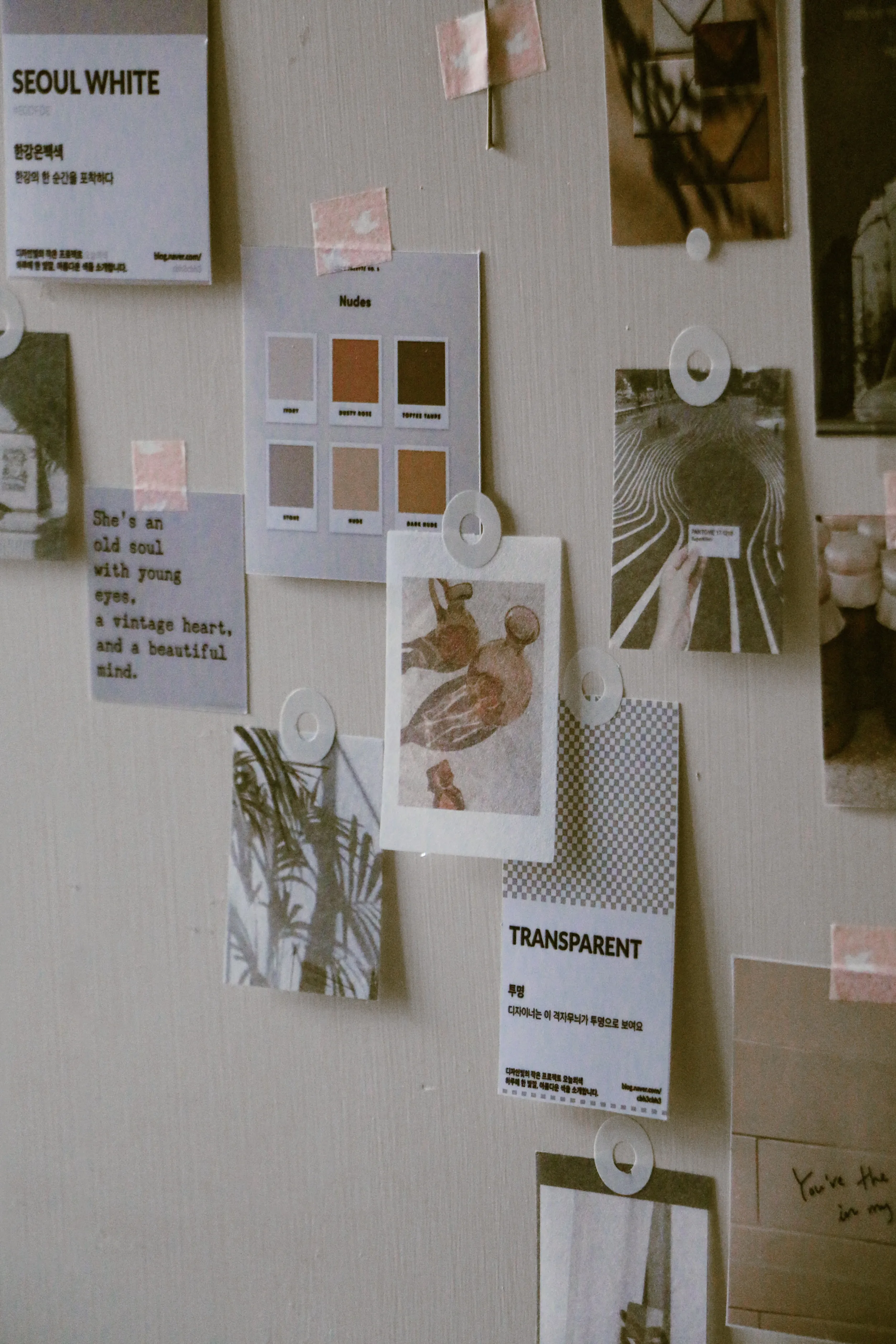 Beiges Moodboard mit Farbkarten, Nude-Palettenmustern und getipptem Zitat, gehalten von Magnetscheiben