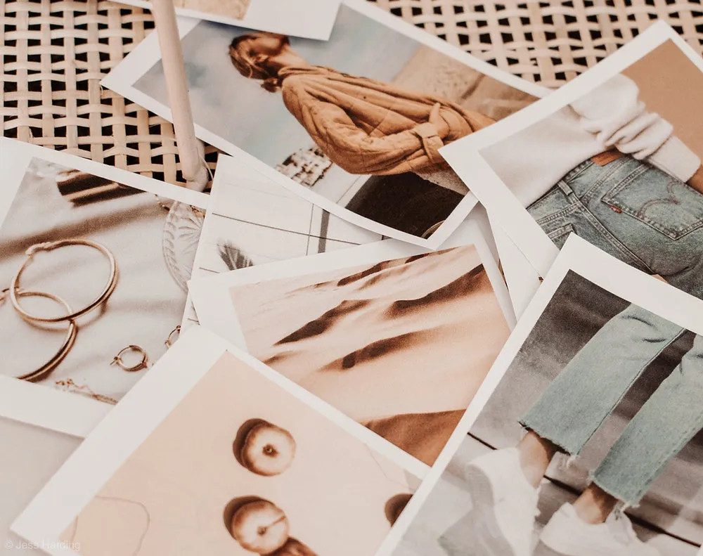 Stapel gedruckter Fotos in warmen Erdtönen auf einem Rattanstuhl – Bilder für eine Moodboard-Collage