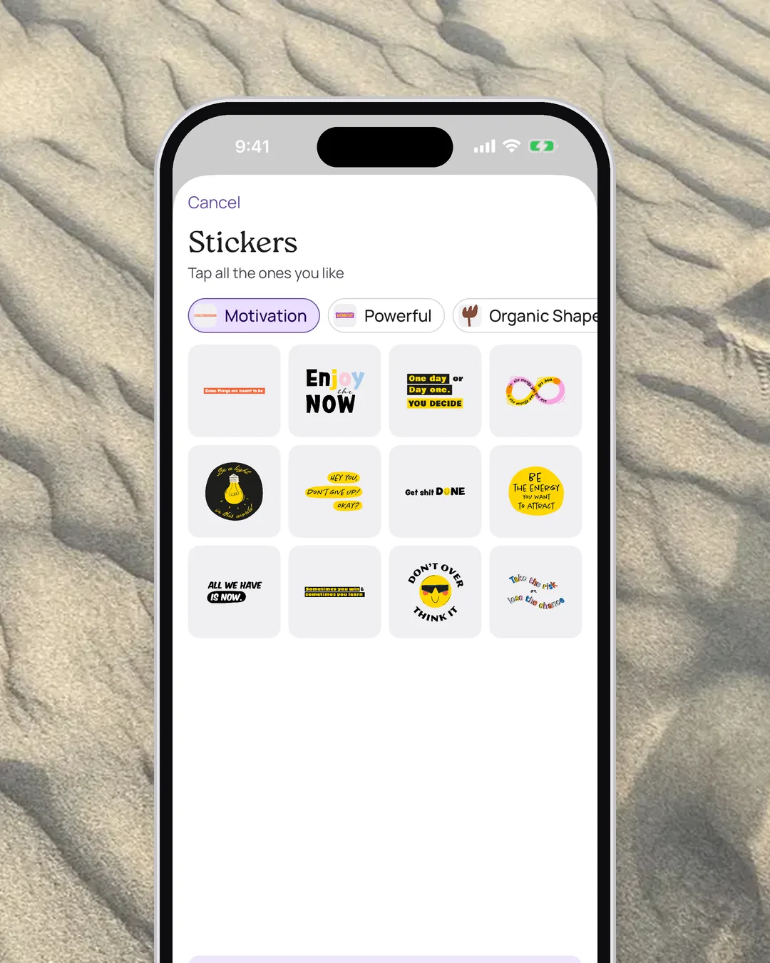 VISIYA sticker packs full of short sayings, on an iPhone over rippled sand