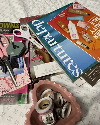 Magazines, two pairs of scissors and a bowl full of washi tape