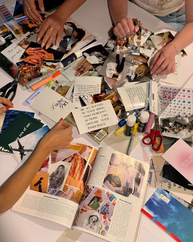 Several hands cutting pictures out of magazines for a collage
